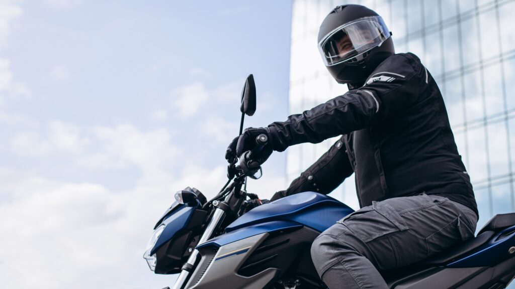 Ein gutaussehender Motorradfahrer auf seinem Motorrad in der Stadt unterwegs