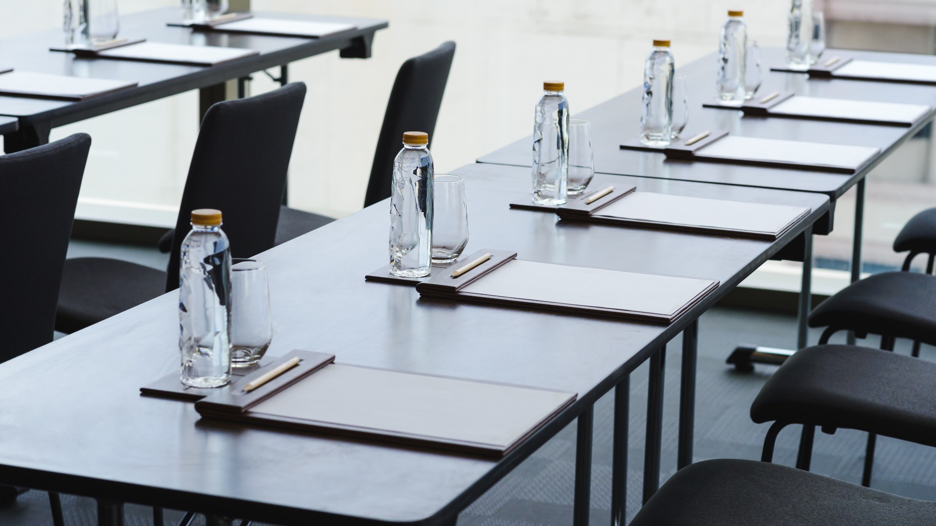 Plastikwasserflaschen, Trinkgläser mit Bleistift und weißem Papier